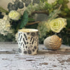 Sleep candle in a Bone China container printed with a hand-drawn illustration of the plants used in the fragrance, including lavender and chamomile. Around the rim is a stripe of shiny 24k gold.